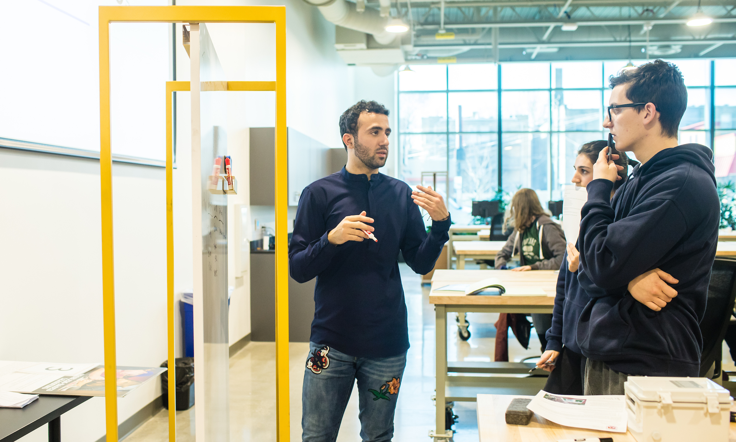 Three engineering students work together in a classroom.